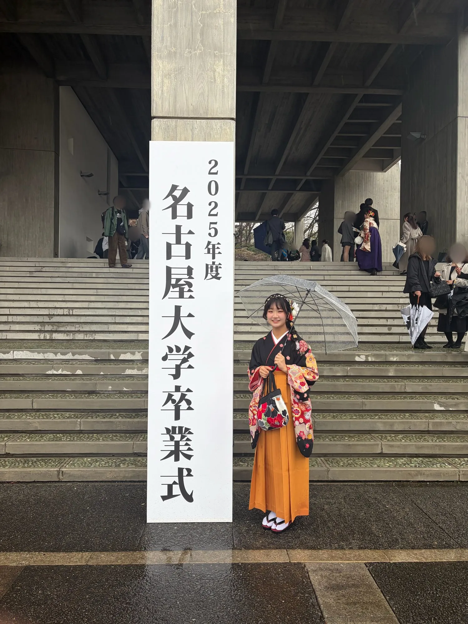 「2025年度 名古屋大学卒業式」の看板の前に袴姿で立つ大石さん