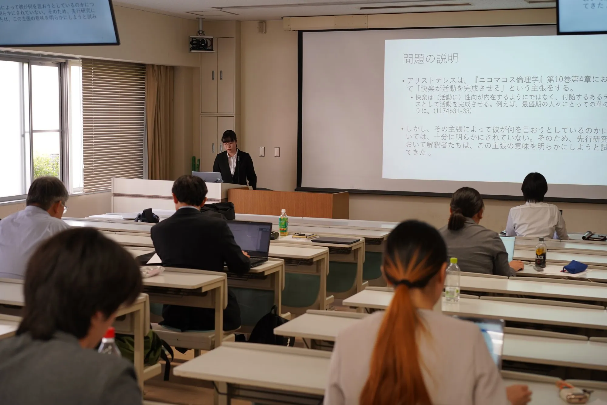 名古屋大学哲学会の研究発表会。演壇の発表者とスライドを見る参加者