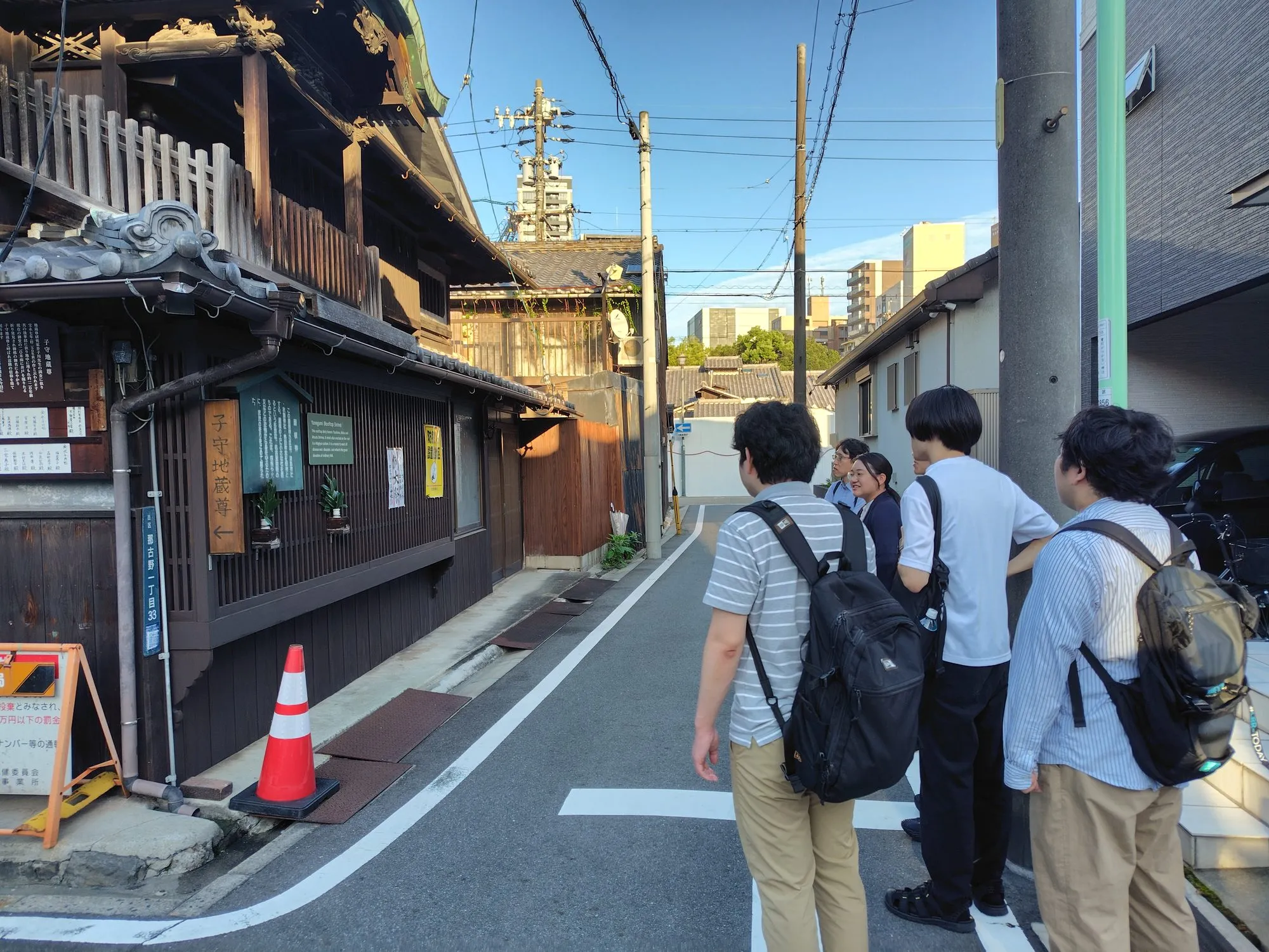四間道界隈の古い町家の前で、通りを眺める研究室のメンバー